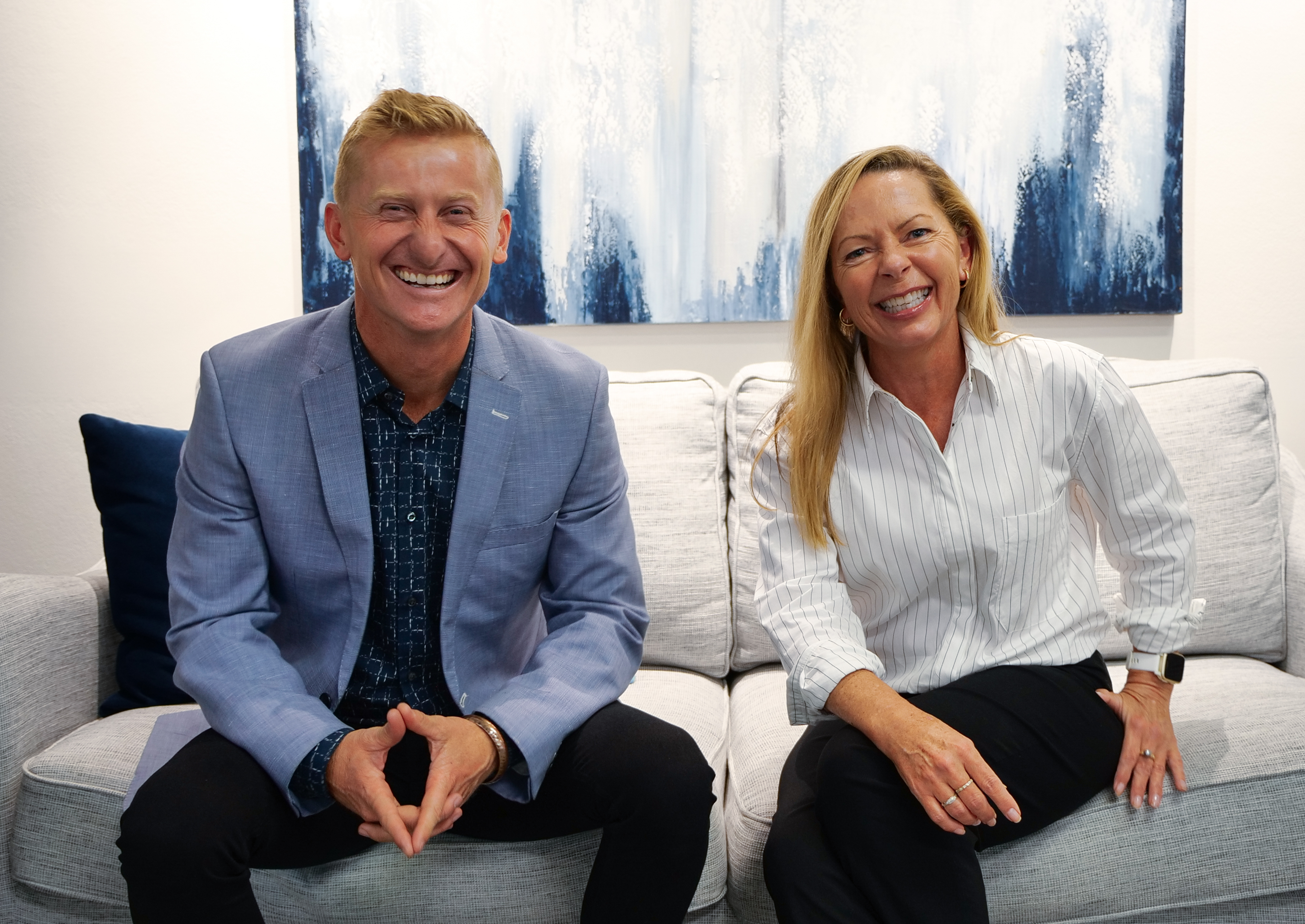 People sitting smiling on a couch